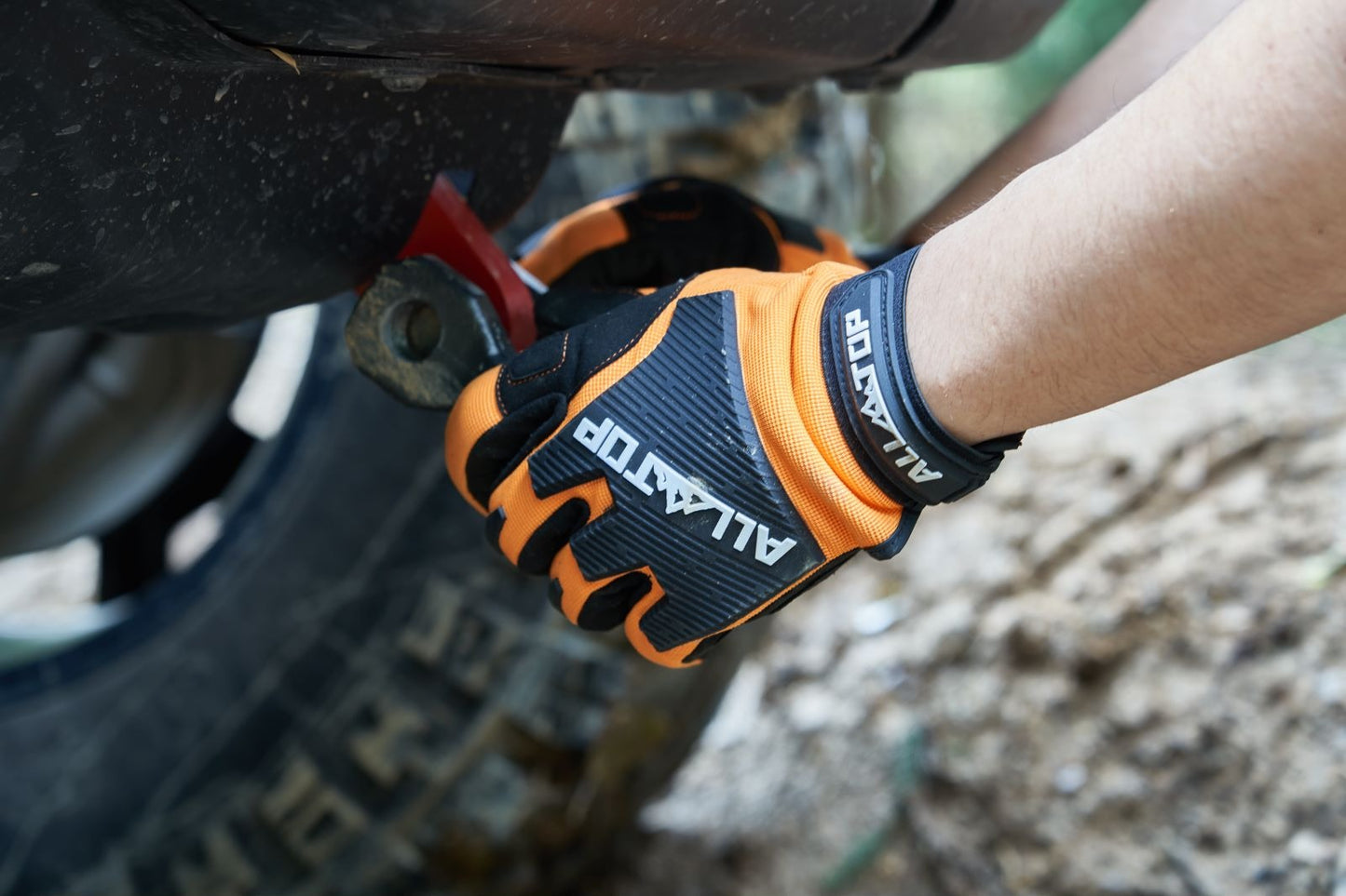 Guantes de Rescate Off-Road ALL-TOP en acción ajustando un componente de vehículo todoterreno